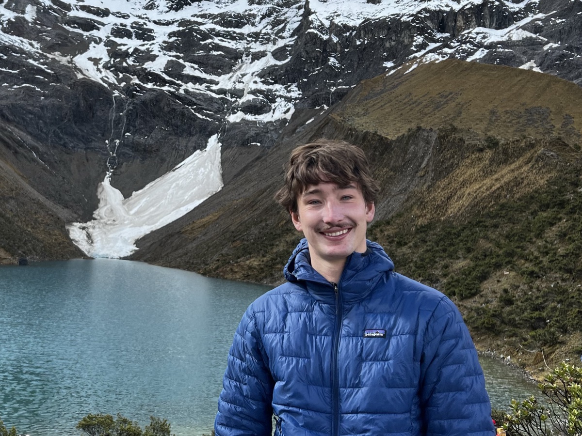 Aiden Jennings in front of a glacial lake and snowy mountains